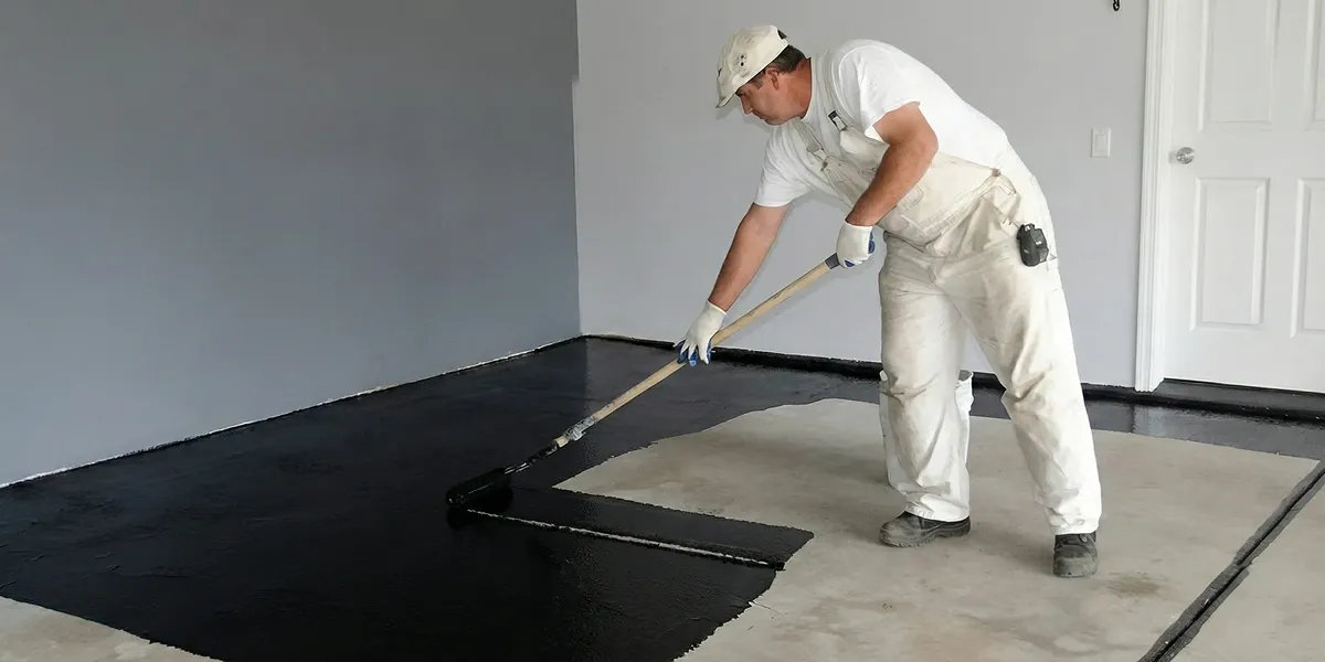 basement waterproofing professional applying waterproof coating to protect a basement floor in Los Angeles, CA