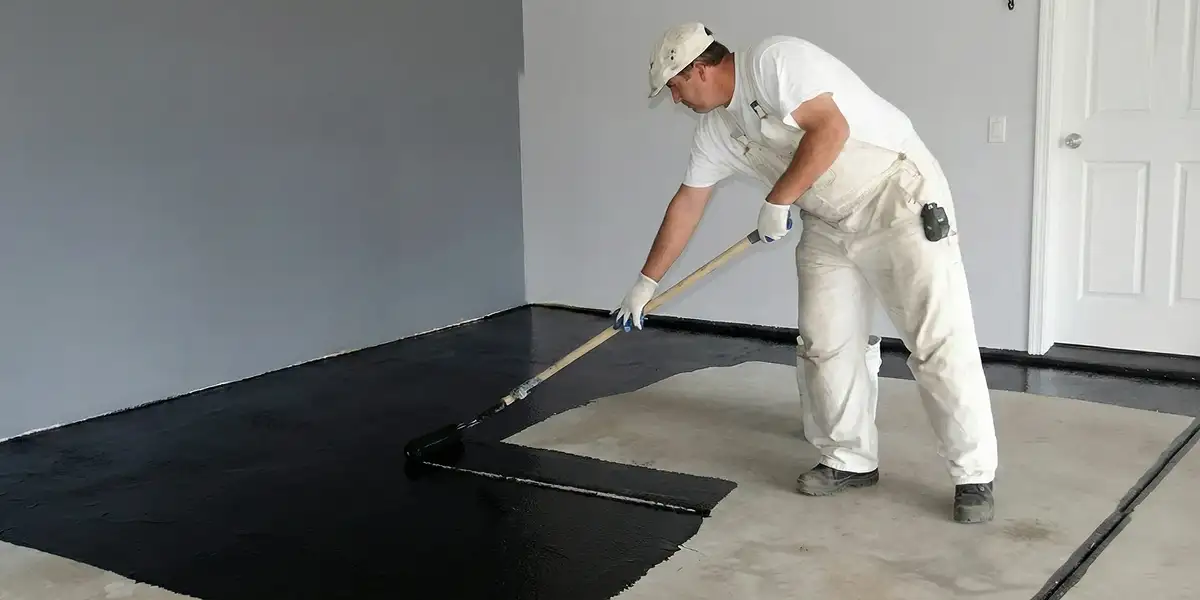 basement waterproofing professional applying waterproof coating to protect a basement floor in Los Angeles, CA